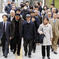 Hopes dashed: Chinese plaintiffs in a suit over wartime forced labor enter the Fukuoka High Court on Monday. | KYODO PHOTO