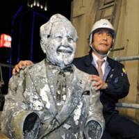 Pitchman: A construction worker shows off the statue of Colonel Sanders pulled from the Dotonbori River in central Osaka on Tuesday. | KYODO PHOTO