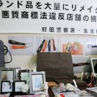 Fancy stash: Confiscated products remade from luxury brand products are shown Tuesday at Machida Police Station in Tokyo. | KYODO PHOTO