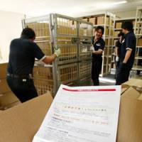 Help is on the way: Workers at Sapporo City Hall on Tuesday move boxes of application forms for the government\'s cash handout program. | KYODO PHOTO
