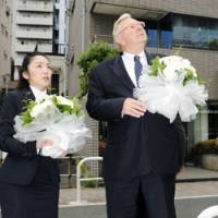 Remembering: John Bundy, president of Schindler Elevator K.K., prepares to offer flowers Wednesday at a Minato Ward, Tokyo, apartment complex where one of the company\'s elevators killed a teenage boy three years ago. | KYODO PHOTO