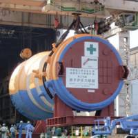 Heavy lifting: A pressure vessel that will contain the nuclear fuel for a power plant in Matsue, Shimane Prefecture, is removed from a plant in Kure, Hiroshima Prefecture, on Tuesday. | KYODO PHOTO