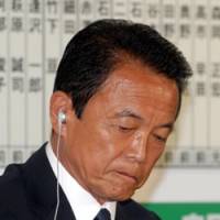 Staggered: Prime Minister Taro Aso faces the media Sunday evening at Liberal Democratic Party headquarters in Tokyo as reports came in of the ruling party\'s crushing defeat. | YOSHIAKI MIURA PHOTO