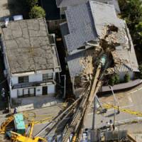 Timber: The top of a pile driver lies in the roof of a house it fell on in Yachiyo, Chiba Prefecture, Thursday morning. | KYODO PHOTO