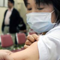 Needlework: A medical worker is innoculated for swine flu Monday at a hospital in Habikino, Osaka Prefecture, as doctors and nurses are given priority in the government vaccination program. | KYODO PHOTO