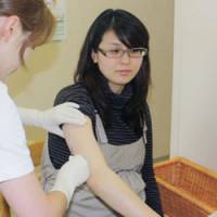 Hold still: A pregnant woman receives a flu vaccination Monday at an obstetrician\'s office in the city of Aomori during the second phase of swine flu inoculations based on risk. | KYODO PHOTO