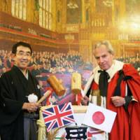 New brew: Koichi Saura (left) of the Japan Sake Brewers Association and Lord Pearson of Rannoch open a barrel of sake at a party held in the House of Lords in London on Wednesday. | KYODO PHOTO