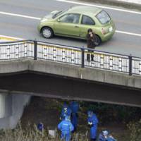 Cold trail: Investigators examine on Tuesday afternoon the spot where the bodies of two dead babies were found in a duffel bag in Matsudamachi, Kanagawa Prefecture. | KYODO PHOTO