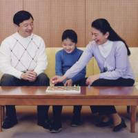 Fun and games: Crown Princess Masako plays a board game with Crown Prince Naruhito and their daughter Princess Aiko in the common room of the Togu Palace residence Nov. 22. | AP PHOTO