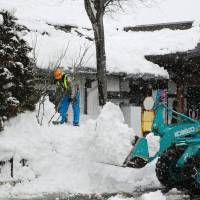 Snow where to go: A worker removes snow around JR Iiyama Station in Iiyama, Nagano Prefecture, on Tuesday. | KYODO