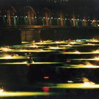 Eel deal: Fishing boats use bright lights to lure glass eel into their traps as they harvest the creatures by a bridge at the headwaters of the Yoshino River in the city of Tokushima. | KYODO