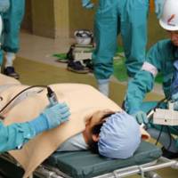 Just a drill: A mock casualty is checked for radiation Thursday during an accident drill at Chugoku Electric Power Co.\'s Shimane nuclear power plant in Matsue, Shimane Prefecture. | KYODO