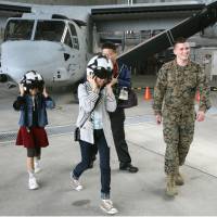 Buckle up: Residents of Ginowan get a chance to take a close look at tilt-rotor Osprey aircraft during a tour of U.S. Marine Corps Air Station Futenma in Okinawa Prefecture on Sunday. u.S. | U.S. FORCES JAPAN/KYODO