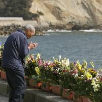 Body and soul: An elderly man prays on a beach in Iwaki, Fukushima Prefecture, on Sunday. | KYODO