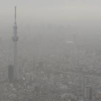 Yellow haze: Tokyo Skytree is barely visible through the dust Sunday. | KYODO