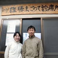 Making a difference: Naoko and Hajime Ishii stand at the entrance of Magonote Clinic in the Ogatsu district of Ishinomaki, Miyagi Prefecture, on Feb. 28. | SATOKO KAWASAKI