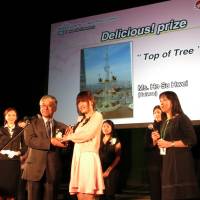 With taste: Ho Su Hwei (center) from Taiwan receives the Delicious category award for her picture for the Share Your Wow! &#8212; Japan Photo Contest hosted by the Japan Tourism Agency on Friday in Kasukabe, Saitama Prefecture. | KAZUAKI NAGATA
