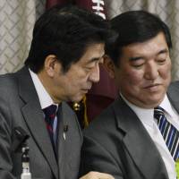 Easy does it: Prime Minister Shinzo Abe (left) confers with Liberal Democratic Party Secretary General Shigeru Ishiba during a meeting Saturday at the ruling party\'s Tokyo headquarters. | KYODO