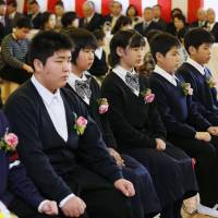 Baby steps: Namie Elementary School students from Fukushima Prefecture attend a graduation ceremony Friday in Nihonmatsu, where the school evacuated to after the 3/11 disasters. | KYODO
