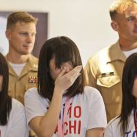 Deepest thanks: U.S. Marine Master Sgt. Howard Tait (right) and Capt. Ben Middendorf stand behind an emotional Mami Onotera on  Tuesday as she and other students from Kesennuma, Miyagi Prefecture, visit San Diego to thank the marines who provided disaster relief in 2011. | AP