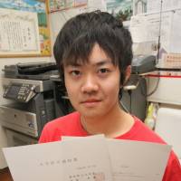 College bound: Rafael Yukio Kusuki shows his acceptance letter from Aichi Prefectural University at a shelter for the homeless in Ichinomiya, Aichi Prefecture, this month. | CHUNICHI SHIMBUN