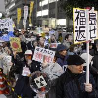 Undeterred: Participants march through Tokyo\'s Nagata-cho political hub Friday evening urging the government to abandon nuclear power, continuing a weekly demonstration that has lasted a year. | KYODO