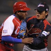 Doing it all: Starting pitcher Hisashi Iwakuma tags out Alfredo Despaigne to end a threat in the sixth inning as Cuba had two men on base at the World Baseball Classic on Wednesday. | AP PHOTO