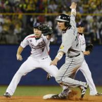 Missed opportunity: Hanshin Tigers baserunner Takahiro Arai is tagged out by Hiroyasu Tanaka in an attempt to steal second during the third inning on Wednesday at Jingu Stadium. The Swallows won 4-2. | KYODO PHOTO