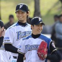 Taking it easy: Fighters pitchers Yu Darvish (left) and Yuki Saito stay relaxed during the team\'s workout on Tuesday. | KYODO PHOTO