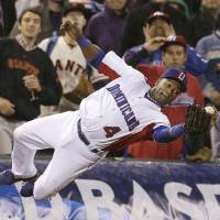 Leap of faith: The Dominican Republic\'s Miguel Tejada catches a foul ball in the seventh inning of his team\'s 3-0 win over Puerto Rico in the World Baseball Classic championship game in San Francisco on Tuesday. | AP