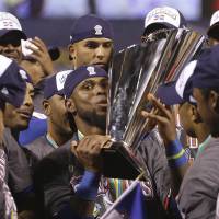 On top of the world: The Dominican Republic\'s Jose Reyes holds the World Baseball Classic trophy after beating Puerto Rico. | AP