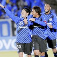 One-man effort: Gamba Osaka midfielder Masato Yamazaki (left) is congratulated by Satoshi Yamaguchi (5) and Lucas after scoring the second of his two goal against Australia\'s Melbourne Victory in their Group G match of the Asian Champions League on Wednesday at Expo Stadium in Osaka. Gamba won 2-0. | KYODO PHOTO