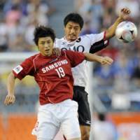 Midsummer battle: K. League All-Star midfielder Lee Kwan Woo (left) and the J. League All-Star\'s Mitsuo Ogasawara compete for the ball during JOMO Cup at National Stadium. The South Korean squad won 3-1. | KYODO PHOTO