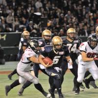 Coming through: Obic quarterback Shun Sugawara runs with the ball during the Japan X Bowl against Fujitsu at Tokyo Dome on Monday. | HIROSHI IKEZAWA PHOTO