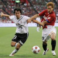 Pitched battle: Shimizu S-Pulse forward Shinji Okazaki fights for the ball with Urawa Reds defender Yuki Abe in the first half of a Nabisco Cup quarterfinal in Saitama on Wednesday. | KYODO PHOTO