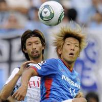 Local derby: Marinos\' Masashi Oguro controls the ball in front of Frontale\'s Kosuke Kikuchi on Sunday. | KYODO