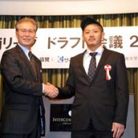 An era begins: Yokohama B-Corsairs guard Kenji Yamada (right) and Toshimitsu Kawachi, the bj-league commissioner, share the spotlight during the league\'s annual draft on Thursday in Tokyo. Yamada, was chosen No. 1 in the rookie draft. | YOSHIAKI MIURA PHOTO