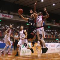 Going all out: Yokohama guard Kenji Yamada (13) attempts a layup as Akita\'s Ricky Woods defends during Game 1 of the bj-league Eastern Conference Semifinals at Yokohama Cultural Gymnasium on Thursday night. | KAZ NAGATSUKA