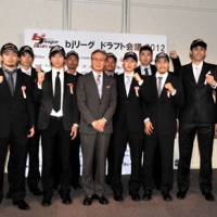 New opportunity: Toshimitsu Kawachi, the bj-league commissioner, stands with new draft selections on Tuesday during the annual draft in Tokyo. | YOSHIAKI MIURA
