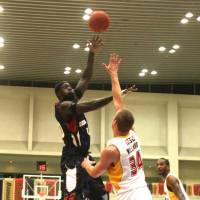 Aiming high: Yokohama center Pape Faye Mour takes a hook shot over Sendai\'s Sam Willard during Friday night\'s game at Ebina Sports Park Gymnasium. The B-Corsairs beat the 89ers 79-68. | KAZ NAGATSUKA