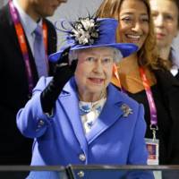 Royal treatment: Queen Elizabeth II waves to the crowd during the swimming competition on Saturday. | AP