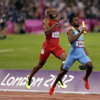 David beats Goliath: Ramon Miller of the Bahamas passes Angelo Taylor of the United States in the homestretch to win the gold in the 4x400-meter relay at the Olympic Stadium on Friday night. | AP