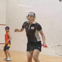 Chinatsu Matsui plays squash Sunday as a young student looks on at Central Sports Yokohama Kita facility during a junior charity tournament. Matsui, a professional since 2002, advanced to the Asian Games quarterfinals. | KAZ NAGATSUKA PHOTO