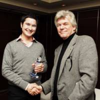 Author Robert Whiting shakes hands with Japan Times sportswriter James Mulligan after presenting him with the trophy for the Best Coverage -- Major Event category at the Foreign Sportswriters Association of Japan Media Awards Dinner in Tokyo on Monday night. | YOSHIAKI MIURA PHOTO