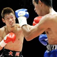 Fistic power: Hozumi Hasegawa connects on a third-round punch against Alvaro Perez of Nicaragua during their WBC bantamweight title bout on Friday in Kobe. Hasegawa retained his title with a fourth-round knockout. | KYODO PHOTO