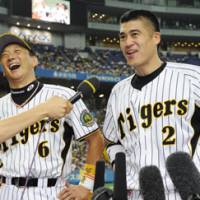 All smiles: Tomoaki Kanemoto (left), Kenji Johjima and the Hanshin Tigers will begin a critical week in the Central League atop the standings. | AP PHOTO