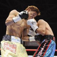 Textbook punch: Daiki Kameda (left) gives a body blow to Takefumi Sakata on Saturday. Kameda defended his WBA flyweight title, defeating his compatriot by unanimous decision at Tokyo Big Sight. | KYODO PHOTO