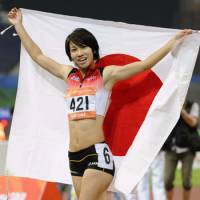 Chisato Fukushima parades the Japanese flag after winning gold in the 100-meter dash at the Asian Games in Guangzhou, China, on Monday. It is Japan\'s first gold in the event in 44 years. | KYODO PHOTOS