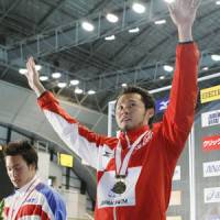 Victory lap: Kosuke Kitajima waves to the crowd after his record-setting swim on Sunday. | KYODO PHOTO