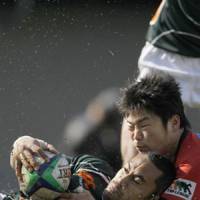 Arm\'s length: Toyota flyhalf Orene Ali keeps the ball out of reach of Sanyo scrum half Fumiaki Tanaka. | AKI NAGAO